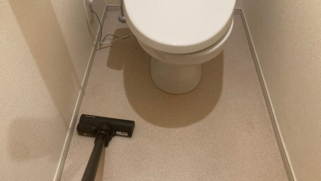 トイレの部屋を掃除機をかける様子